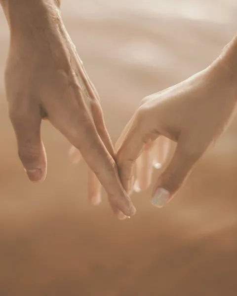 Las manos de una pareja rozándose por la punta de los dedos
