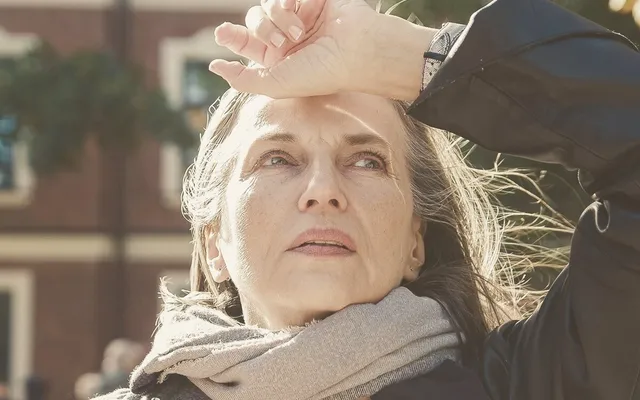 Mujer en la calle llevándose la mano a la frente, con gesto de despiste